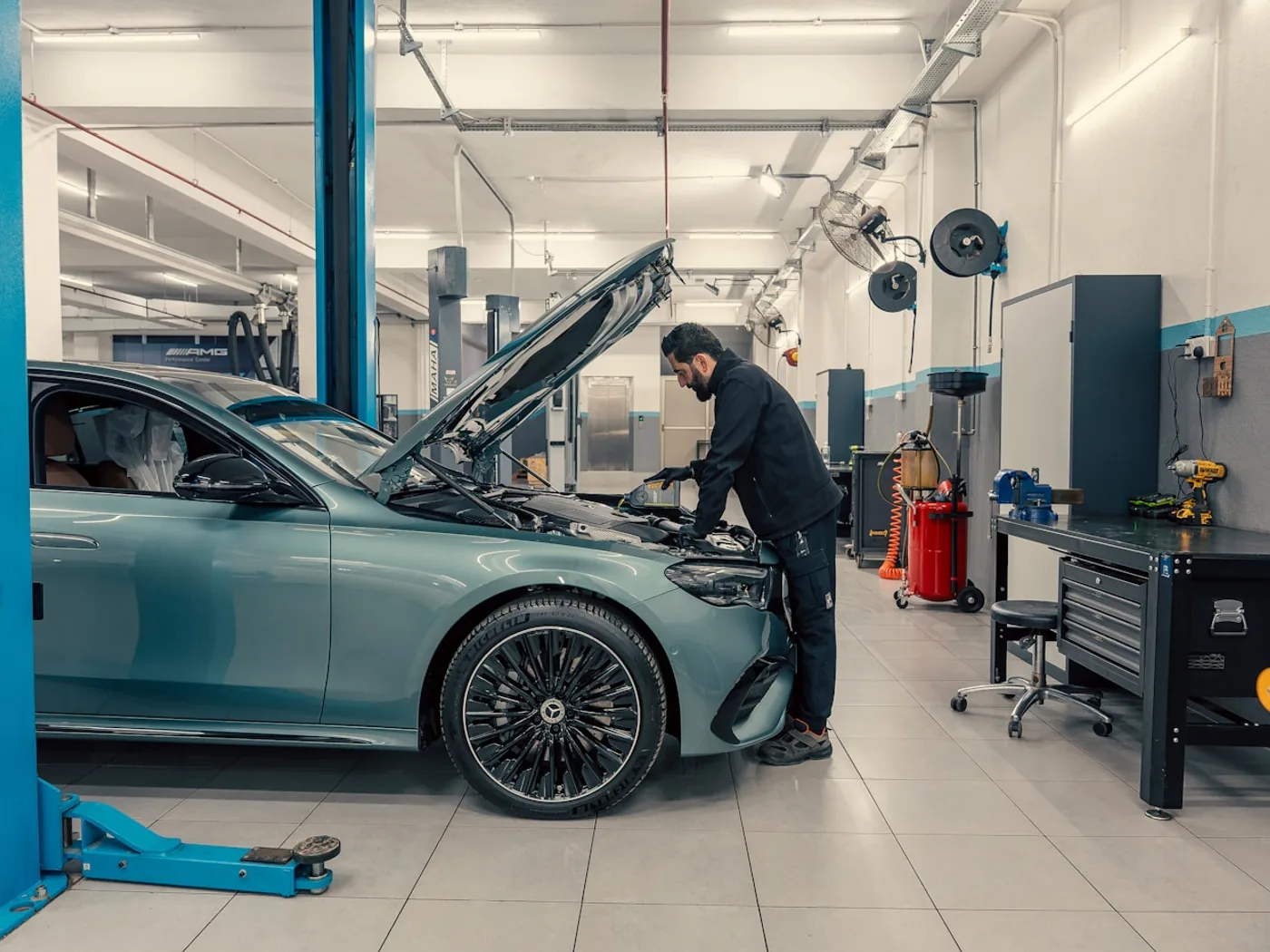 Fahrzeug auf der Hebebühne in einer hellen Werkstatt, Motorhaube offen